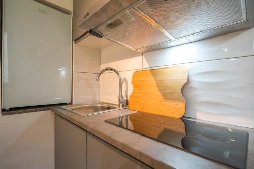 - une cuisine avec un évier et une planche de coupe en bois dans l'établissement Résidence du Parc, à Fontenay-aux-Roses