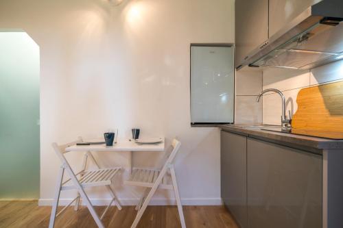 une petite cuisine avec une table et deux chaises dans l'établissement Résidence du Parc, à Fontenay-aux-Roses