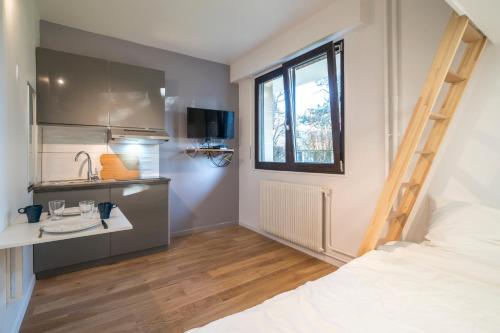 Cette petite chambre comprend un lit et une cuisine. dans l'établissement Résidence du Parc, à Fontenay-aux-Roses
