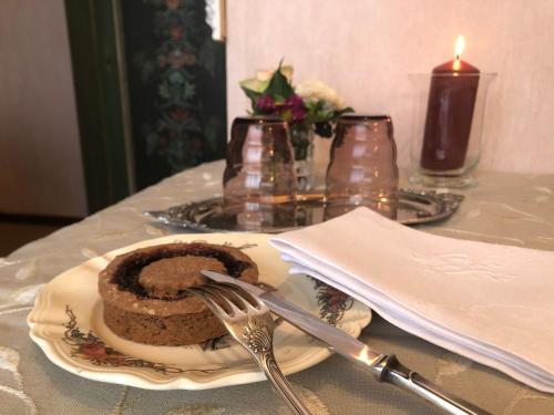 a plate with a chocolate cake on a table with a candle at La Maison de juliette in Saint-Hippolyte
