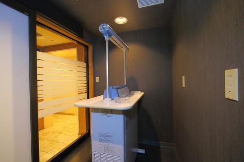 a room with a sink with a light on it at Hotel Regina Kawaguchiko in Fujikawaguchiko