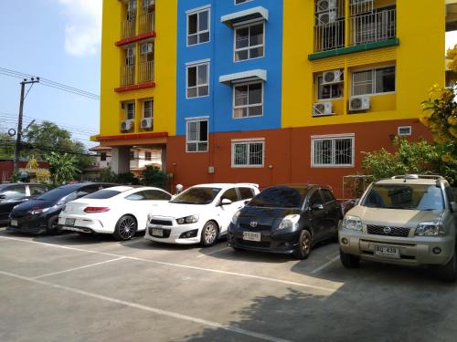 a group of cars parked in a parking lot in front of a building at ฐิติกร แกรนด์วิว in Thanya Buri