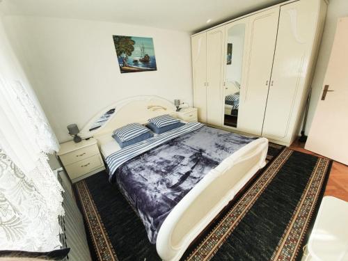 - une chambre avec un grand lit et un miroir dans l'établissement Apartman Goran - 130m Radiochirurgia, à Sveta Nedjelja