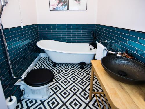 a bathroom with a tub and a toilet and a sink at Luxury Travel Emporium HG1 - 2 Luxury apartments with Parking Space - in town centre in Harrogate