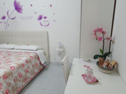 una camera da letto con un letto e un tavolo con fiori sul muro di Le tre orchidee a Salerno