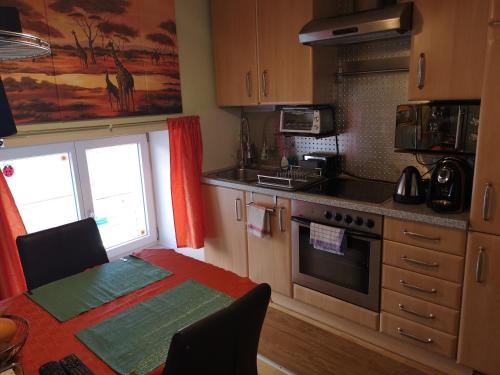 eine Küche mit einem Tisch und einem Herd Top-Backofen in der Unterkunft Oranges Apartment in Gmunden