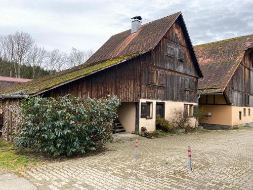 a large wooden building with a roof at Bio Hofgut Wiggenweiler in Bermatingen