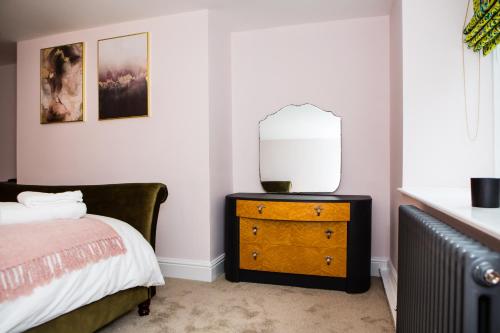 a bedroom with a bed and a dresser with a lamp at Luxury Travel Emporium HG1 - 2 Luxury apartments with Parking Space - in town centre in Harrogate