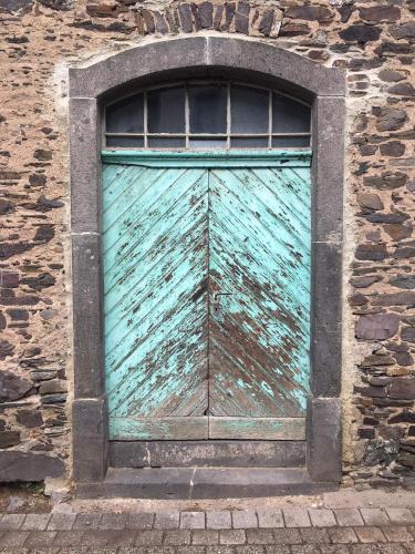 a green garage door in a brick building at MOSELTEL Ernst,Cochem in Ernst