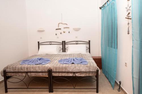 a bedroom with a bed with blue towels on it at Bella Vita Style rooms & apartments in Pitsidia