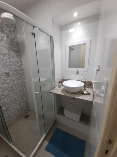 y baño blanco con lavabo y ducha. en Casa Itapuca, en Niterói
