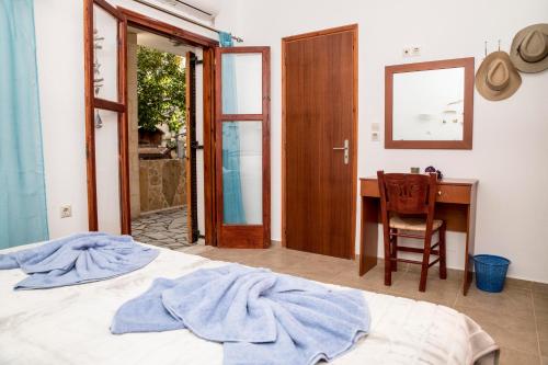 a bedroom with a bed and a desk and a chair at Bella Vita Style rooms & apartments in Pitsidia