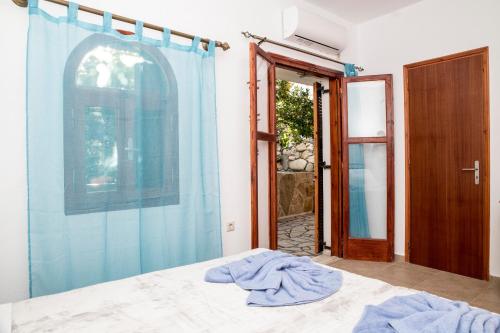 a bedroom with a blue shower curtain and a bed at Bella Vita Style rooms & apartments in Pitsidia
