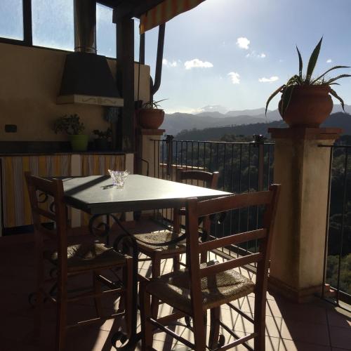 a table and chairs on a balcony with a view at B&B Il Padrino in Savoca 
