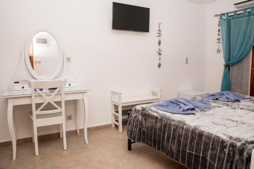a bedroom with a bed and a desk and a mirror at Bella Vita Style rooms & apartments in Pitsidia