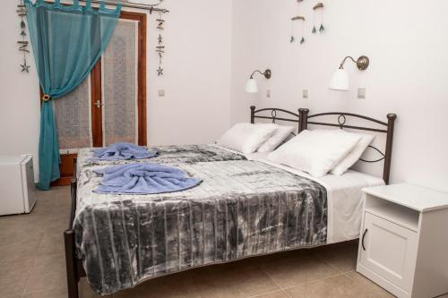 a bedroom with a bed and a blue curtain at Bella Vita Style rooms & apartments in Pitsidia