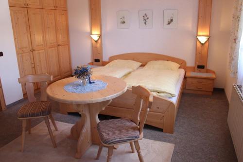 a bedroom with a bed and a table with a bed at Haus STRIEDER - Obergail in Liesing