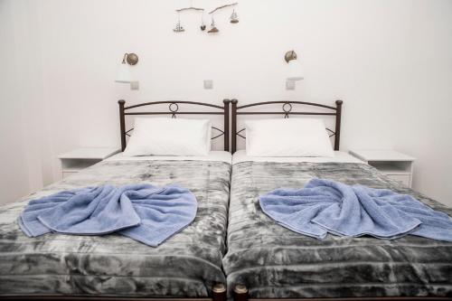 a bed with two blue towels on it at Bella Vita Style rooms & apartments in Pitsidia