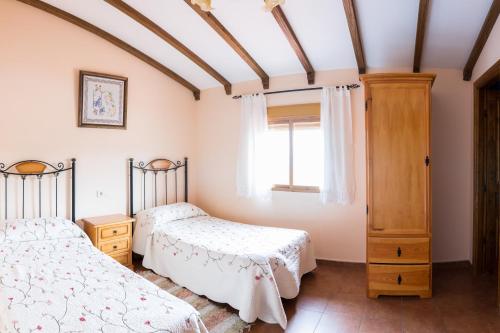 1 dormitorio con 2 camas y ventana en Las Calabazas en Barrado