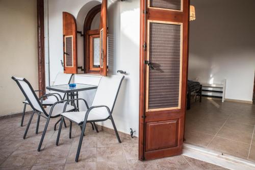 a dining room with a table and chairs and a door at Bella Vita Style rooms & apartments in Pitsidia