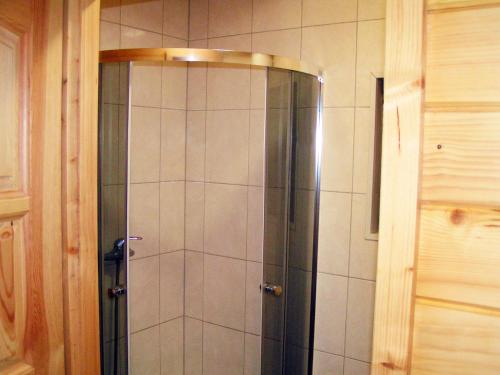 a shower with a glass door in a bathroom at Wantaris - domki letniskowe z ogródkiem in Mielno