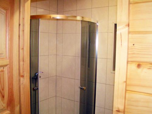 a shower with a glass door in a bathroom at Wantaris - domki letniskowe z ogródkiem Mielno-Mielenko in Mielno