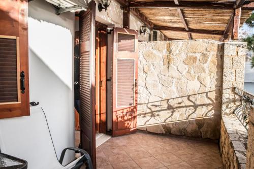 a door to a house with a stone wall at Bella Vita Style rooms & apartments in Pitsidia