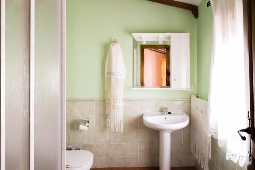 a bathroom with a sink and a toilet and a mirror at Las Calabazas in Barrado