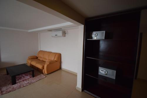 a living room with a brown chair and a table at Noble House Hotel in Kumasi
