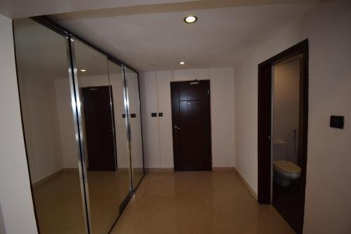 a bathroom with a glass shower and a toilet at Noble House Hotel in Kumasi