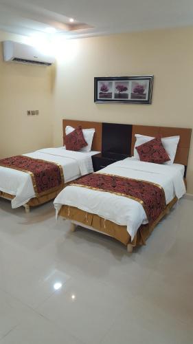 two beds in a hotel room with at Aros Al Faisaliah Furnished Units in Dammam