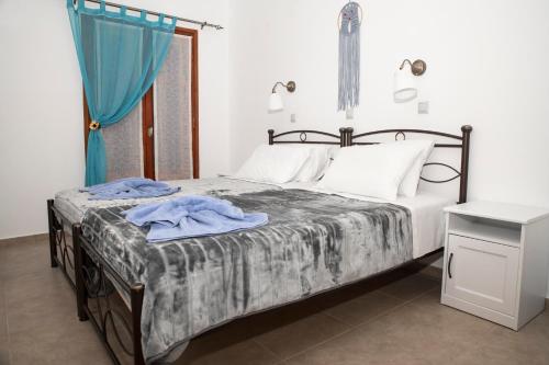 a bedroom with a bed with a blue blanket on it at Bella Vita Style rooms & apartments in Pitsidia