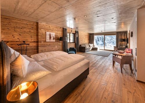a bedroom with a large bed and a living room at Skilodge Oberlech in Lech am Arlberg