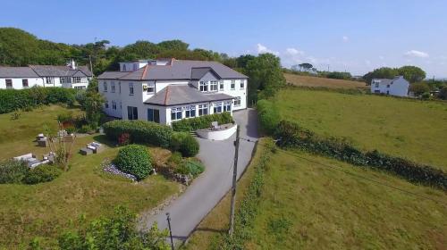 an aerial view of a large white house with a driveway at Beacon Country House Hotel & Luxury Shepherd Huts in St. Agnes 