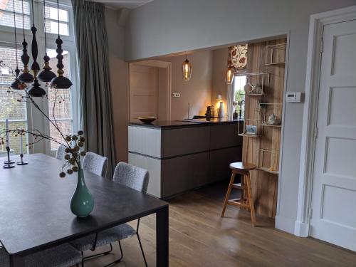 - une cuisine et une salle à manger avec une table et un comptoir dans l'établissement ootmen, à Wolphaartsdijk