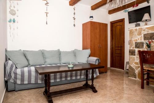 a living room with a couch and a table at Bella Vita Style rooms & apartments in Pitsidia