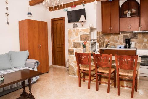 a kitchen and living room with a table and chairs at Bella Vita Style rooms & apartments in Pitsidia