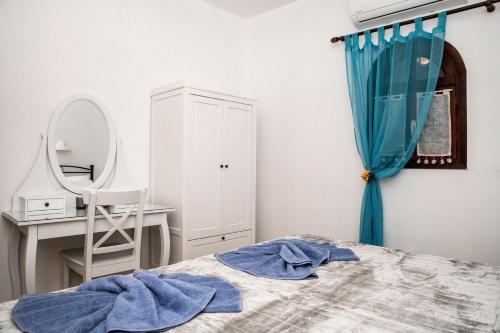 a bedroom with a bed with a mirror and a dressing table at Bella Vita Style rooms & apartments in Pitsidia