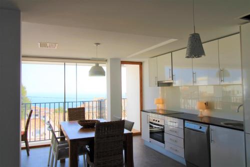 a kitchen with a table and a view of the ocean at Hostal Fornet Altea in Altea