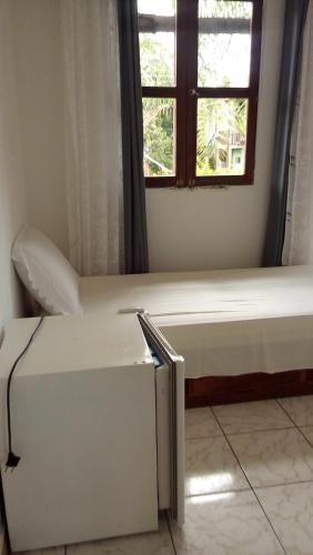 a bed in a room with a window at Suítes Novo Amanhecer in Sao Jorge