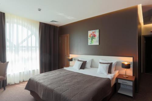 a hotel room with a large bed and a window at WISH Aqua&SPA Resort in Vishenki