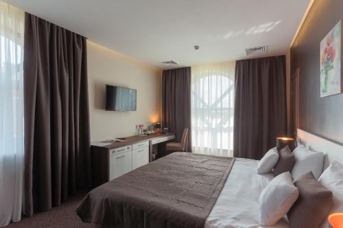 a hotel room with a bed and a desk at WISH Aqua&SPA Resort in Vishenki
