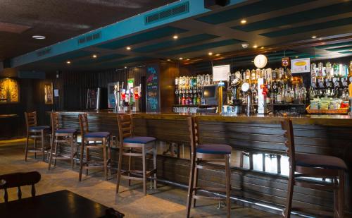 a bar with bar stools in a restaurant at Holiday Inn Aberdeen West by IHG in Westhill 