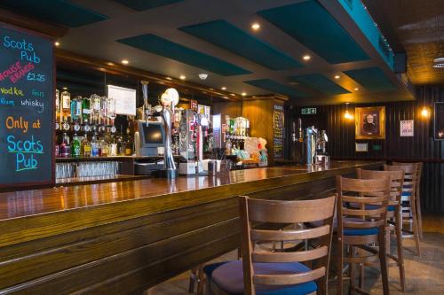a bar with chairs and a counter with a bartender at Holiday Inn Aberdeen West by IHG in Westhill 
