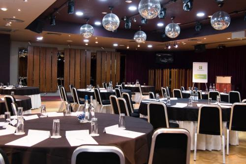 a conference room with tables and chairs and lights at Holiday Inn Aberdeen West by IHG in Westhill 