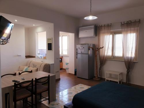 a kitchen and living room with a refrigerator and a table at Fronte Mare a Venetico in Venetico