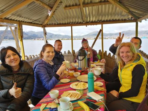 a group of people sitting at a table eating food at Urosfood & Titiqaqa Lodge in Uros