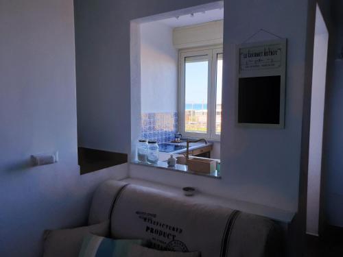 a bathroom with a sink and a window with a view at Fronte Mare a Venetico in Venetico