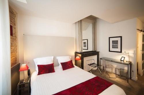 A bed or beds in a room at Hôtel des Arts