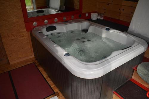 a bath tub filled with water in a bathroom at Petit Gîte avec SPA en Ariege Montagnes des Pyrénées in Péreille